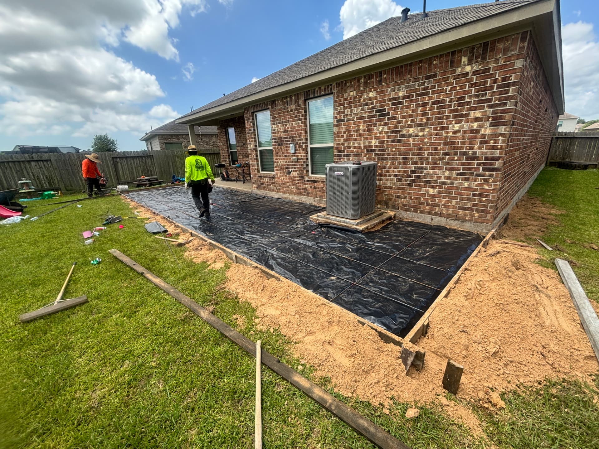 Tucker Built Co crew setting forms, vapor barrier and rebar for a League City patio slab